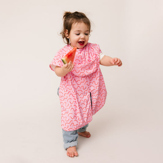 Abibi long sleeve smock bib, bright playful print, keeps clothes clean during mealtimes
