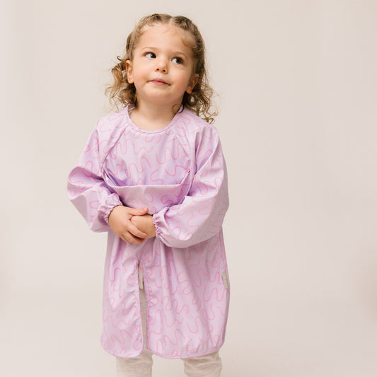 Abibi long sleeve smock bib, bright playful print, keeps clothes clean during mealtimes