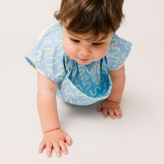 Abibi long sleeve smock bib, bright playful print, keeps clothes clean during mealtimes