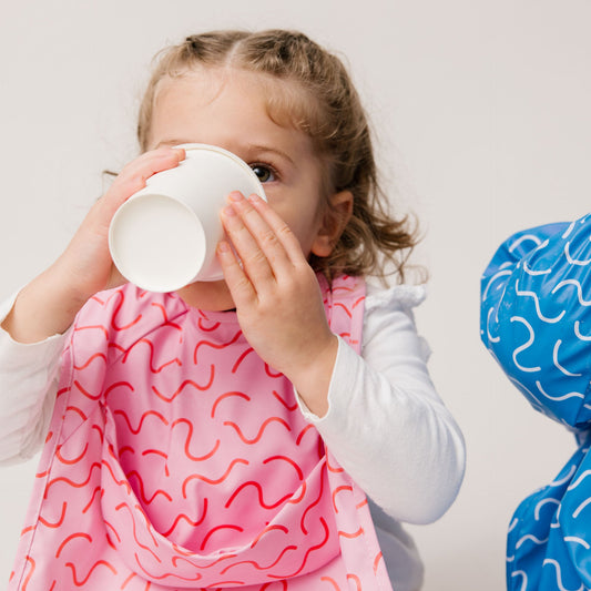 Abibi long sleeve smock bib, bright playful print, keeps clothes clean during mealtimes