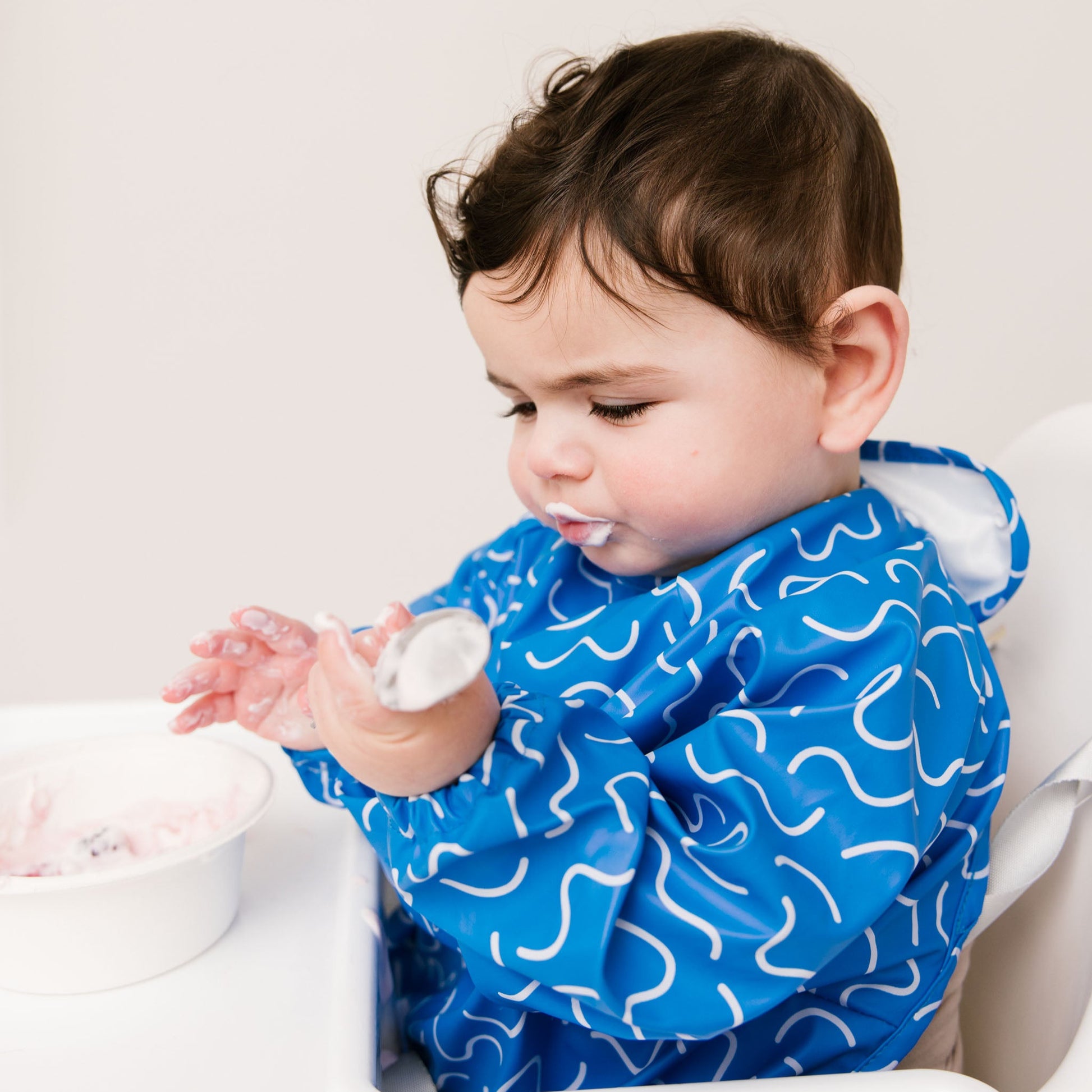 Abibi long sleeve smock bib, bright playful print, keeps clothes clean during mealtimes